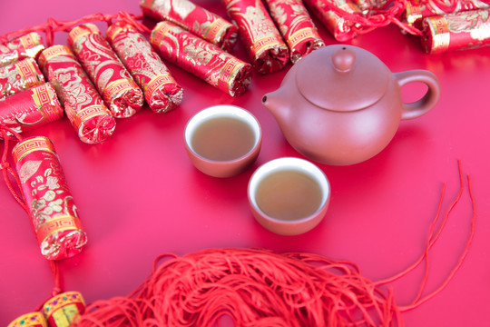 喜庆红背景上的鞭炮装饰和茶饮