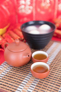 喜庆背景上的一碗汤圆和茶饮