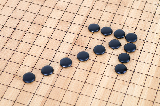 黑色围棋子棋盘上组成的箭头符号