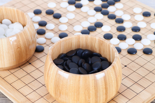 棋盘上散落的棋子和装满棋子的木