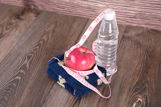 一瓶水和软尺苹果及毛巾