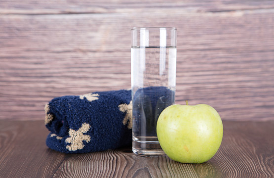 毛巾和一杯水及一个青苹果