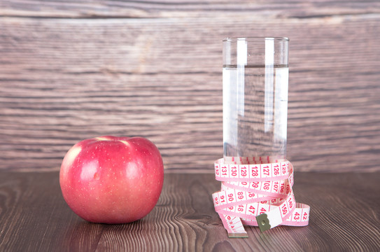 一个苹果和被尺子缠绕的一瓶水