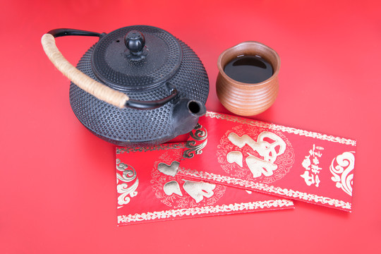 红背景上的茶壶茶杯和红包