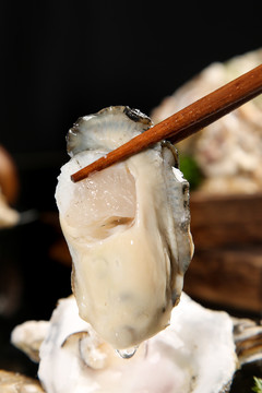 筷子夹着生蚝肉
