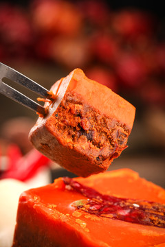 叉子叉着一块红油火锅底料