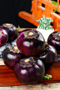 木板上放着紫圆茄子