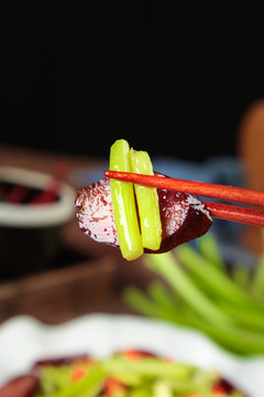 筷子夹着腊肠炒蒜苔