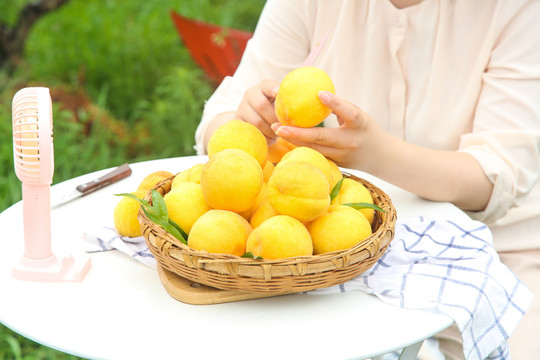 桌子上放着一篮子新鲜黄桃