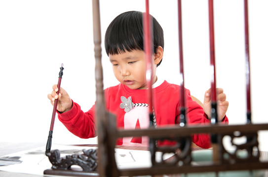 白背景前练习书法的小女孩