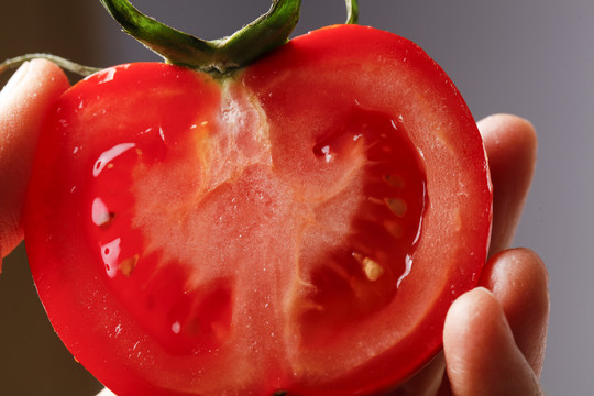 手拿切开的番茄