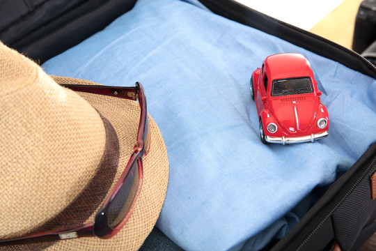 行李箱里的衣服和帽子及小汽车