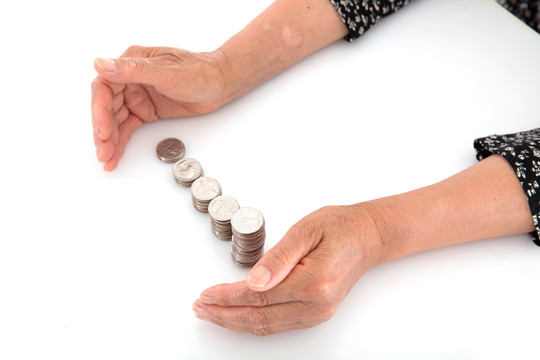 老年人的手呵护着一排美元硬币