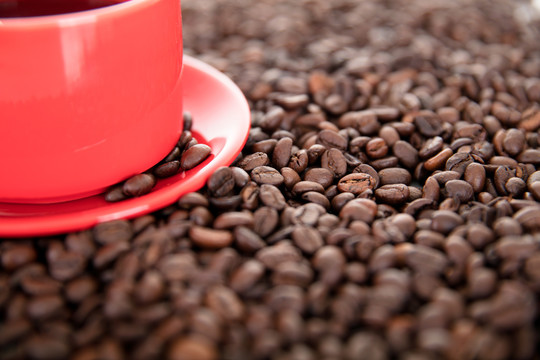 咖啡豆铺满的背景上一杯咖啡饮品