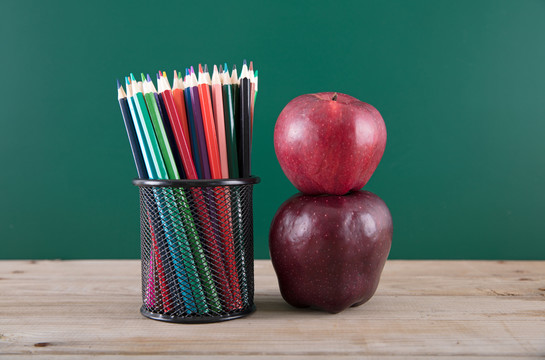 彩铅笔的笔筒和一个红苹果