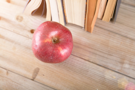 俯视桌子上图书边一个红苹果