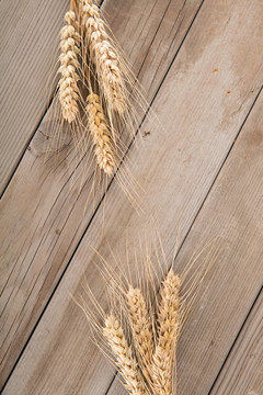 木质背景上两把成熟了的小麦麦穗