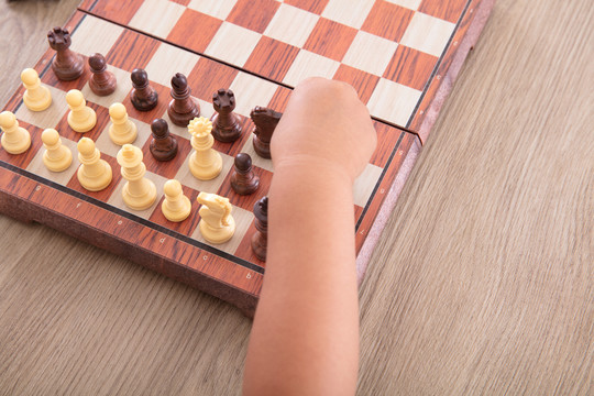 特写小孩子的手正在下国际象棋