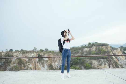 年轻的亚泰黑头发旅行家女子用相机拍照。春布里。科罗拉多大峡谷