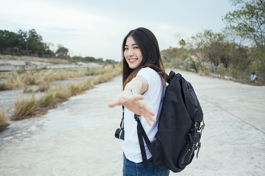 年轻的亚裔泰国长黑发旅行家女子伸手对着镜头。科罗拉多大峡谷春布里。