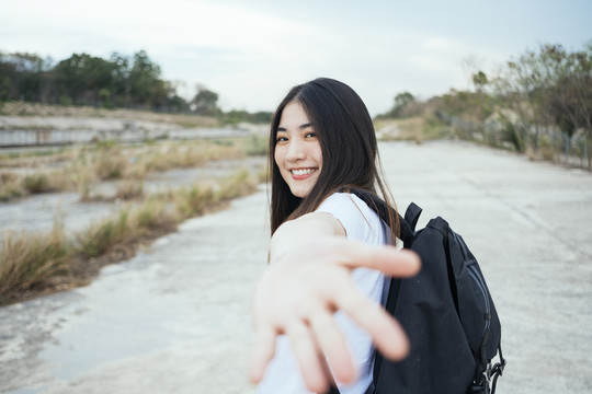 年轻的亚裔泰国长黑发旅行家女子伸手对着镜头。科罗拉多大峡谷春布里。