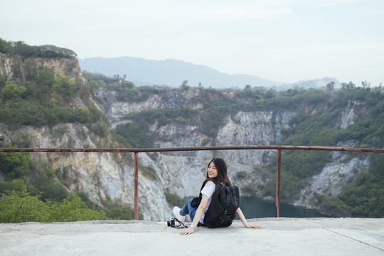 在大峡谷，一位年轻的亚裔泰国长毛女旅行者坐在地板上。春布里。