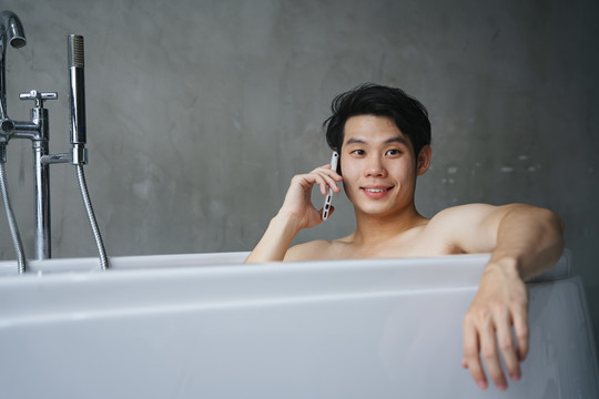 亚洲年轻人喜欢在浴缸里洗澡时使用智能电话。