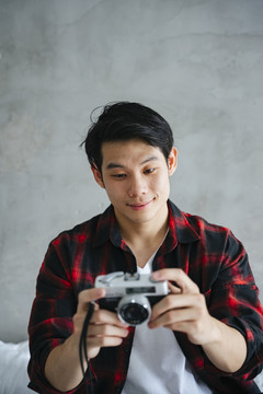 年轻的亚洲摄影师手持复古胶卷相机的肖像。