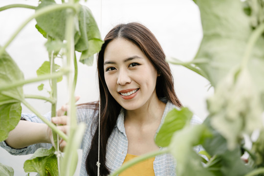 温室农场里快乐的亚洲女人的特写照片。