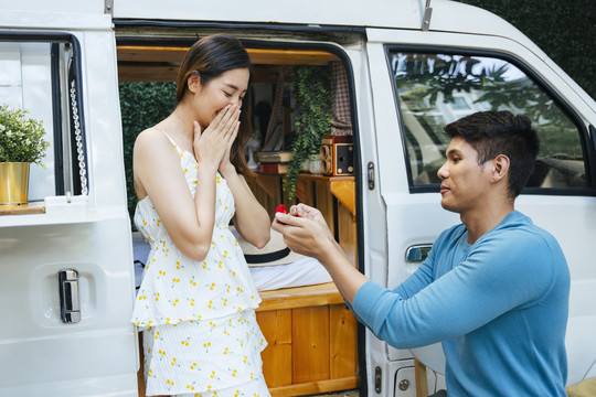 一对亚洲夫妇提议在房车附近结婚。男人在和女友旅行时求婚。