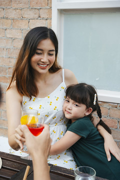 亚洲孩子和母亲互相拥抱，在家里庆祝派对。