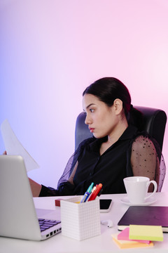 亚洲女商人黑发在办公室阅读文件。
