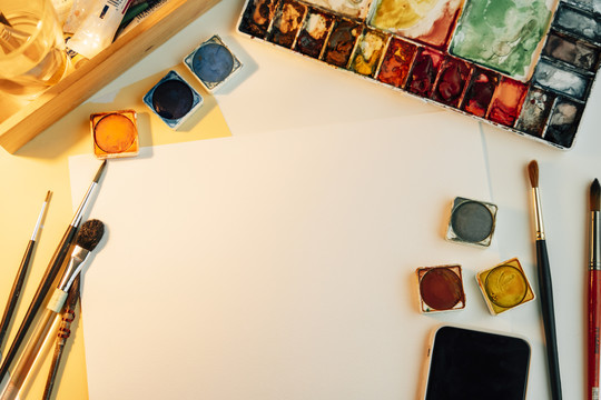 顶视图-艺术家工作台，配备彩色喷漆设备和纸模型。