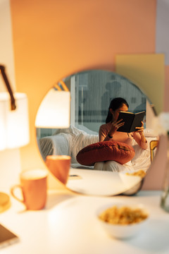 女人睡觉前在卧室里开灯看书。