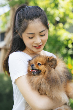 美丽的亚洲女人和她可爱的波美拉尼亚斯皮茨狗。