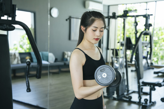 侧视图-健康的亚洲女性在健身房与Duckell一起锻炼。