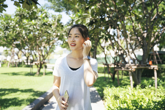 夏季在公园小路上跑步或慢跑的运动型亚洲女性。