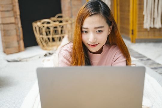 前视图-在笔记本电脑上工作的亚洲美女。