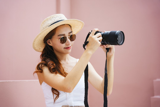带着数码相机的年轻旅行家亚洲女人。