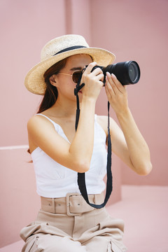 带着数码相机的年轻旅行家亚洲女人。