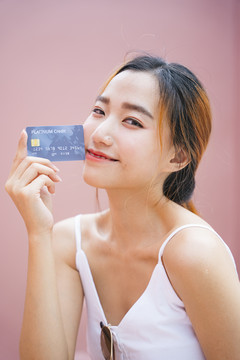 美丽的年轻亚洲女人的肖像，带着信用卡。