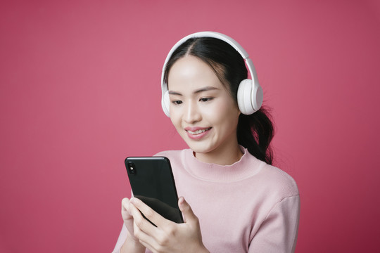在音乐流媒体应用程序上搜索歌曲的年轻亚洲女性肖像。