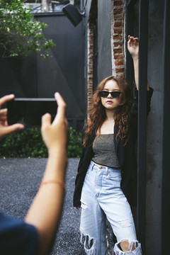 年轻亚洲女性用智能手机拍照的时尚肖像。