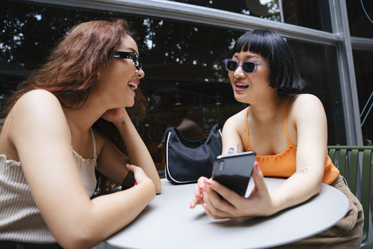 年轻的亚洲时髦女孩在智能手机上的在线购物应用程序中查看销售资料。