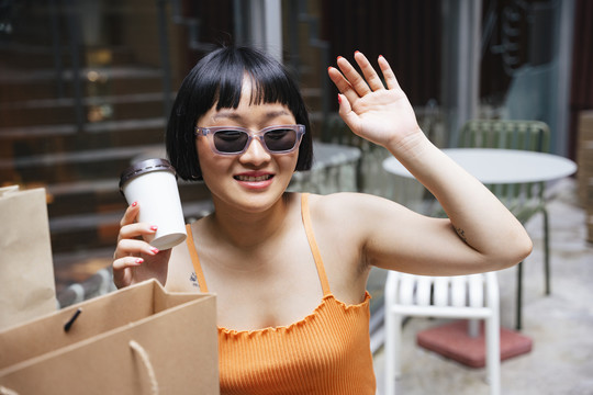 一位年轻的亚洲女士打电话给咖啡馆的服务员点了些食物。