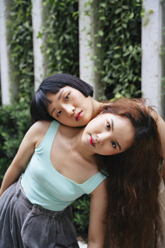 两位年轻亚洲女性在现代公园的时尚肖像。