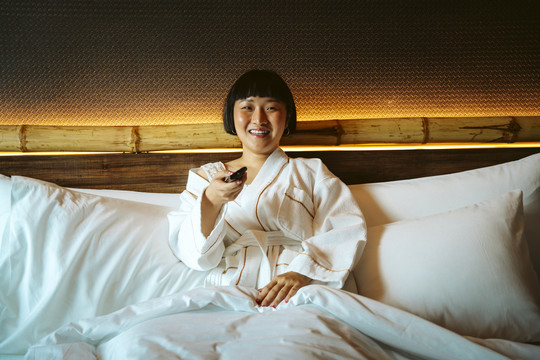 亚洲短发女人喜欢独自在卧室看电视剧。
