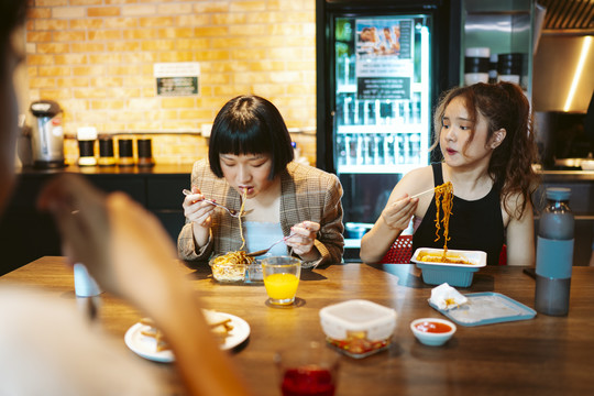 年轻的亚洲商人们在厨房里一起吃午餐。