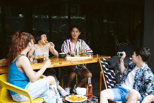 一群亚洲年轻人在酒店休息室享受夏日旅行的乐趣。