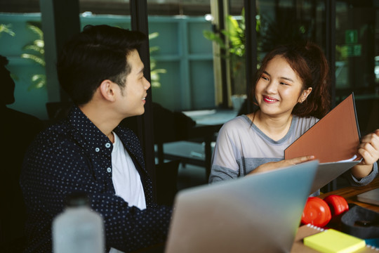 一对亚洲商人夫妇在咖啡馆一起工作。